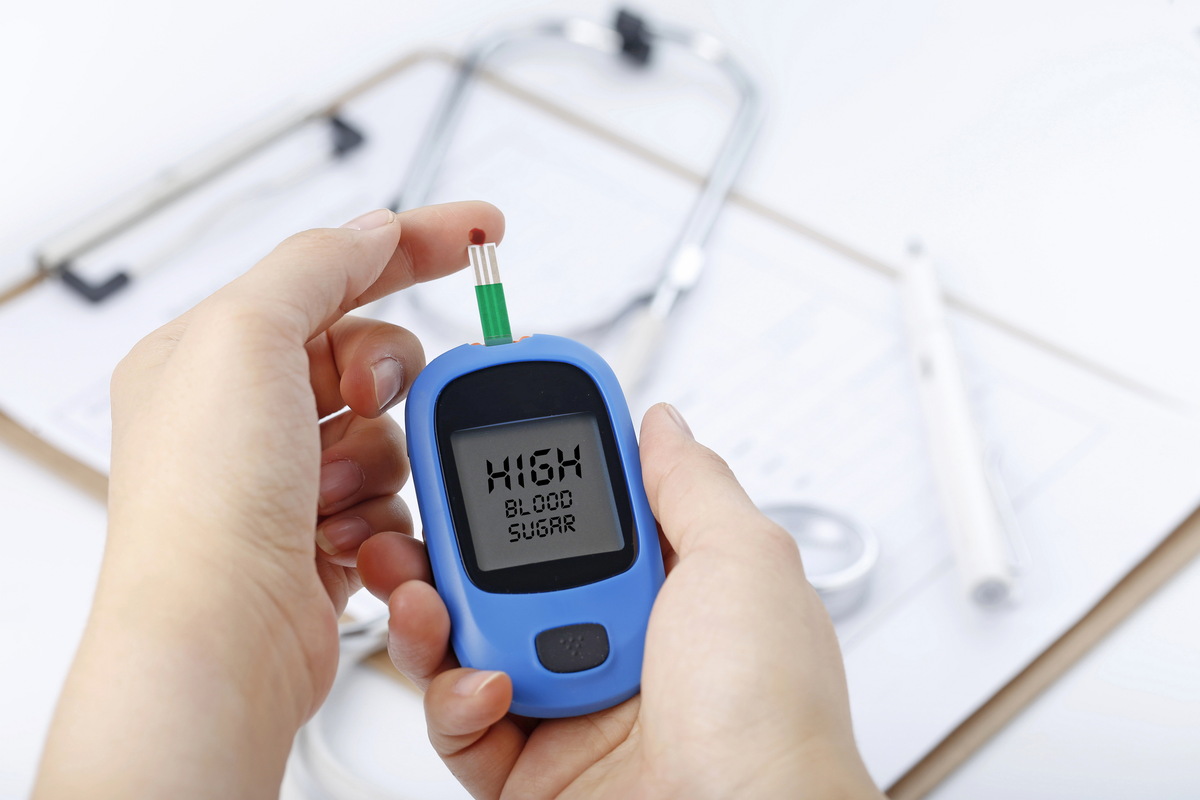 Hand holding a blood glucose meter measuring blood sugar the background is a stethoscope and chart file - オーガニック素材を使用した無添加の2960グラノーラ